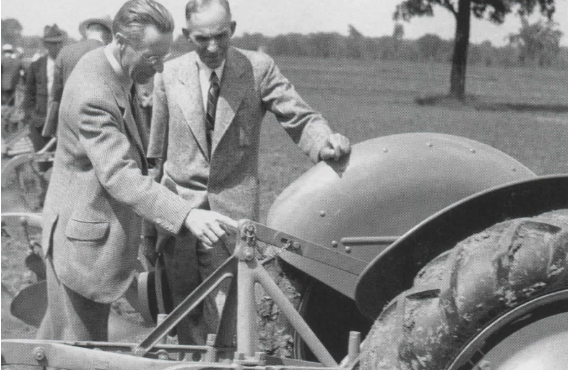 Harry Ferguson and Henry Ford examining a Ferguson tractor linkage in 1938